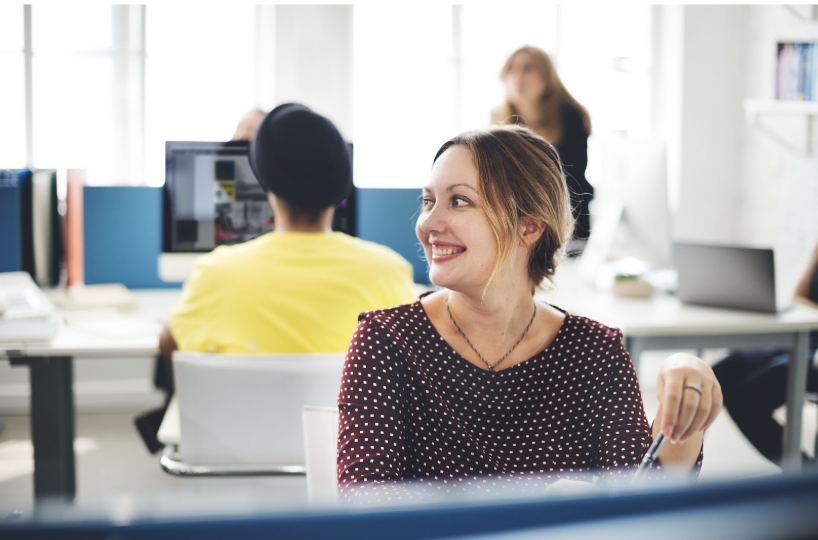 Empleados trabajando en oficina limpia y organizada en Barcelona, reflejando el impacto positivo de las empresas de limpieza de oficinas en Barcelona en la productividad.