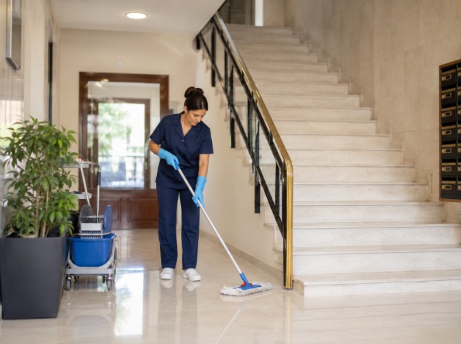 Profesional realizando limpieza de comunidades en portal y escaleras 