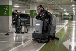 Equipo profesional realizando la limpieza de parking con maquinaria industrial en un aparcamiento moderno.